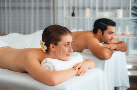 Téléchargez les photos : Couple caucasien client appréciant relaxant massage spa anti-stress et dorloter avec beauté loisirs de la peau dans la lumière du jour salon de spa ambiant à la station de luxe ou hôtel. Tranquillité - en image libre de droit