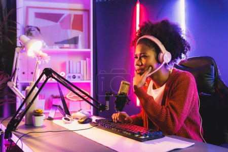 Photo for African American girl streamer disappointed playing online fighting with Esport skilled team wearing headphones in neon room. Talking other players planing strategies to win competitors. Tastemaker. - Royalty Free Image