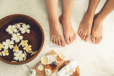 Téléchargez les photos : Couple se livre à un massage des pieds heureux au salon de spa de luxe pour la thérapie de réflexologie dans la station de lumière du jour douce ambiance ou spa des pieds de l'hôtel. Tranquillité - en image libre de droit