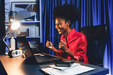 Photo for Working African woman with happy glowing, smiling face, getting new job project with good deal or marketing course scholarship information on laptop screen. Concept of cheerful expression. Tastemaker. - Royalty Free Image