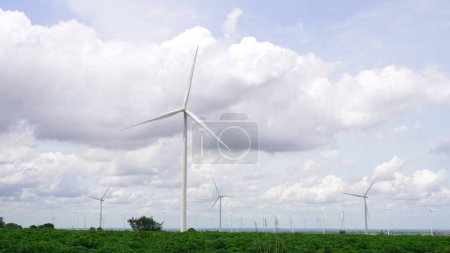 Téléchargez les photos : Manière progressive d'utiliser l'énergie éolienne comme source d'énergie renouvelable pour alimenter le mode de vie moderne par un parc d'éoliennes sur un champ vert ou une colline. Générateur d'éoliennes produire électrique sans émission de CO2. - en image libre de droit