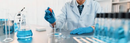 Photo for Scientist conduct chemical experiment in medical laboratory, carefully drop precise amount of liquid from pipette into test tube for vaccine drug or antibiotic development. Neoteric - Royalty Free Image