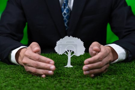 Photo for Businessman holding tree icon symbolize eco-friendly business corporation committed to environmental friendly CSR practice and zero carbon emission. Corporate responsible for greener society. Gyre - Royalty Free Image