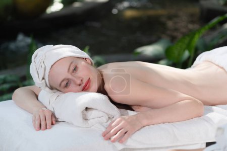 Photo for Portrait of young attractive caucasian women with beautiful skin lies on spa bed while waiting for body massage surrounded by relaxing natural environment. Healthy and beauty concept. Tranquility. - Royalty Free Image