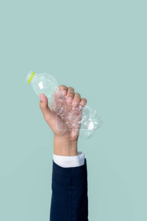 Photo for Businessmans hand holding plastic bottle on isolated background. Eco-business recycle waste policy in corporate responsibility. Reuse, reduce and recycle for sustainability environment. Quaint - Royalty Free Image