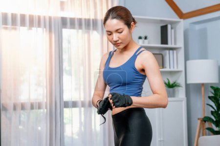 Photo for Fit young asian woman portrait in sportswear preparing herself before healthy exercising routine at home. Domestic fitness workout training on living room. Vigorous - Royalty Free Image