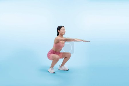 Téléchargez les photos : Femme énergique vigoureuse faisant de l'exercice. Jeune athlète asiatique femme force et endurance séance d'entraînement comme séance de routine d'entraînement squat. Studio complet tourné sur fond isolé. - en image libre de droit