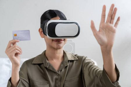 Photo for Young woman using virtual reality VR goggle at home for uttermost online shopping experience. The virtual reality VR innovation optimized for digital entertainment lifestyle. - Royalty Free Image
