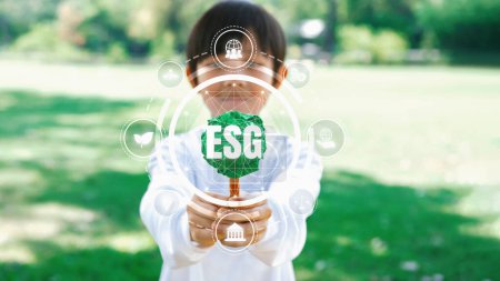 Photo for Little kid nurturing plant with eco icon symbolize natural preservation for future sustainable generation by growing plant to reduce carbon emission and using ESG green technology. Panorama Reliance - Royalty Free Image