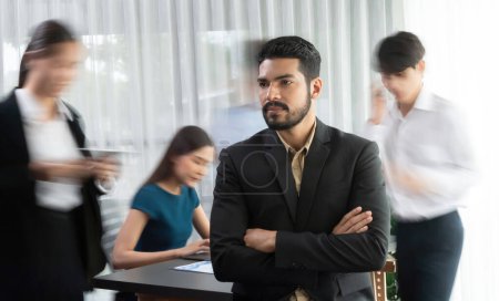 Photo for Businessman portrait poses confidently with diverse coworkers in busy meeting room in motion blurred background. Multicultural team works together for business success. Concord - Royalty Free Image