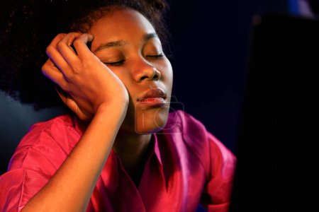 Photo for Exhausted and sleepy young African businesswoman taking a nap in her arm on desk at home office. Concept of thinking a lot projects until sleeping among unfinished online work. Tastemaker. - Royalty Free Image