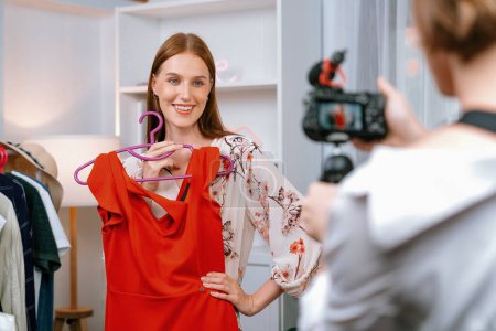 Photo for Woman influencer shoot live streaming vlog video review clothes utmost social media or blog. Happy young girl with apparel studio lighting for marketing recording session broadcasting online. - Royalty Free Image