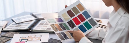 Photo for Interior architect designer at workstation table choosing various color samples art tool design with home blueprint. Creative color selection for house renovation or design concept. Insight - Royalty Free Image