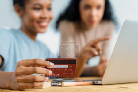 Photo for Young happy woman buy product by online shopping at home while ordering items from the internet with credit card online payment system protected by crucial cyber security from online store platform - Royalty Free Image