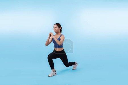 Photo for Young attractive asian woman in sportswear stretching before fitness exercise routine. Healthy body care workout with athletic woman warming up on studio shot isolated background. Vigorous - Royalty Free Image