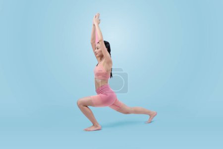 Téléchargez les photos : Femme asiatique en vêtements de sport faisant de l'exercice de yoga en position debout sur la forme physique comme sa routine d'entraînement d'entraînement. Soins du corps sains et mode de vie de yoga de méditation en plan complet sur fond isolé. Vigoureux - en image libre de droit