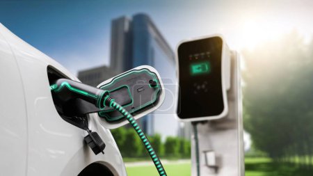 Photo for Electric car plug in with charging station to recharge battery with electricity by EV charger cable in eco green city park. Future innovative EV car using alternative clean energy reducing CO2. Peruse - Royalty Free Image