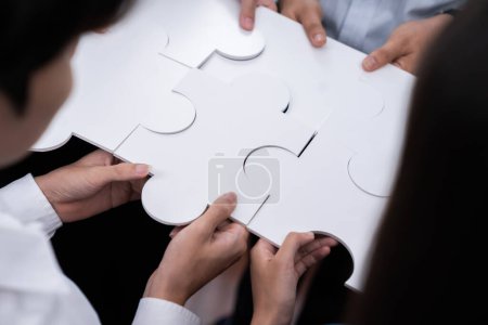 Téléchargez les photos : Divers employés d'entreprise collaborent au bureau, reliant des pièces de puzzle pour représenter le partenariat et le travail d'équipe. Unité et synergie dans le concept d'entreprise en fusionnant puzzle. Concord - en image libre de droit