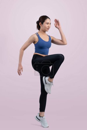 Foto de Vista lateral joven atlética mujer asiática en la ejecución de la postura en el estudio de tiro sobre fondo aislado. Búsqueda de la forma saludable cuerpo físico y ejercicio cardiovascular concepto de estilo de vida de ejercicio. Vigoroso - Imagen libre de derechos