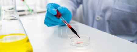 Photo for Scientific laboratory researcher drop blood sample on microscopic slide for medical examination or develop new diagnostic tool. Microbiologist or medical worker conduct experiment in lab. Rigid - Royalty Free Image