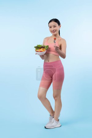 Foto de Joven mujer asiática deportiva en ropa deportiva sosteniendo ensaladera llenar con vibrante de frutas y verduras. Estilo de vida corporal joven y en forma natural con nutrición de equilibrio sobre un fondo aislado. Vigoroso - Imagen libre de derechos