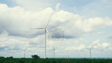 Photo for Progressive way of utilizing wind as renewable source of energy to power the modern way of life by wind turbine farm on green field or hill. Windmill generator generate electric with no CO2 emission. - Royalty Free Image