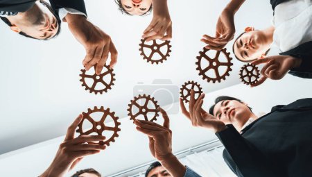 Photo for Below view group of multiracial business people joining gear wheels together as effective unity and productive teamwork concept. Efficient system business team process for solution solving. Habiliment - Royalty Free Image