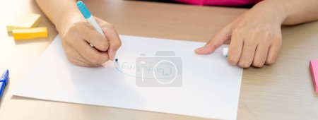 Téléchargez les photos : Une image recadrée de femme d'affaires écriture à la main marketing sur papier avec crayon et des notes collantes placées sur la table. Création d'entreprise et concept de travail d'équipe. Concentrez-vous. Varié. - en image libre de droit