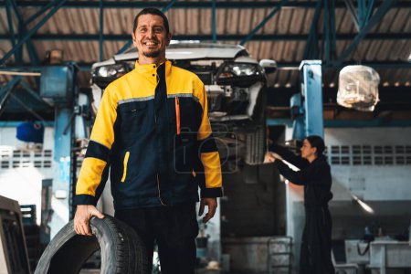 Photo for Confident and happy mechanic portrait with smile and wearing uniform standing on automotive service workshop with car lifted on vehicle inspection station background. Oxus - Royalty Free Image