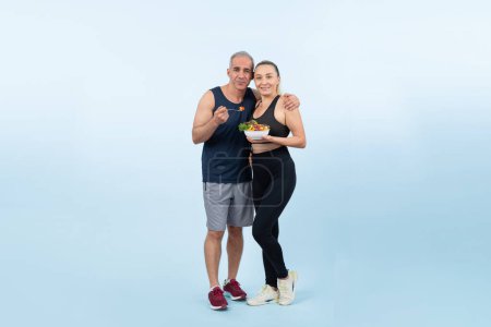 Photo for Happy smile senior man and woman portrait holding bowl of vegan fruit and vegetable on isolated background. Healthy senior couple with healthy vegetarian nutrition and body care lifestyle. Clout - Royalty Free Image