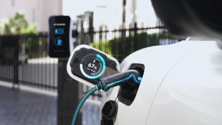 Photo for Electric car recharge with EV charger at futuristic car park utilization of charging station display battery status hologram for rechargeable EV car using alternative and sustainable energy.Peruse - Royalty Free Image