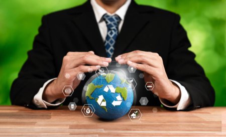 Empresario sosteniendo y protegiendo la Tierra con símbolo de reciclaje. Compromiso empresarial con la protección medioambiental sostenible y las prácticas de reciclado de residuos para un ecosistema más limpio. Dependencia