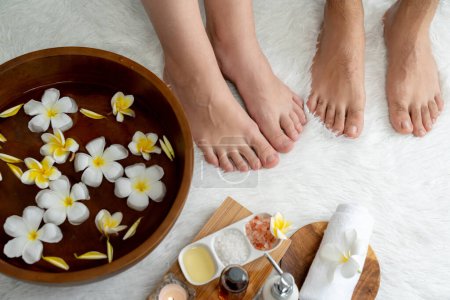 Téléchargez les photos : Couple se livre à un massage des pieds heureux au salon de spa de luxe pour la thérapie de réflexologie dans la station de lumière du jour douce ambiance ou spa des pieds de l'hôtel. Tranquillité - en image libre de droit