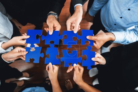 Photo for Top view multiethnic business people holding jigsaw pieces and merge them together as effective solution solving teamwork, shared vision and common goal combining diverse talent. Meticulous - Royalty Free Image