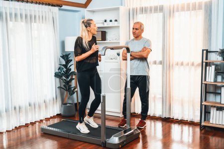 Photo for Active senior couple running on tread running machine at home together in full body shot as fitness healthy lifestyle and body care after retirement for pensioner. Clout - Royalty Free Image