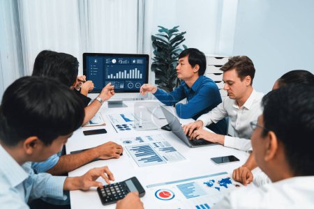 Photo for Analyst team utilizing BI Fintech to analyze financial data at table in meeting room. Businesspeople analyzing BI dashboard power for business insight and strategic marketing planning. Prudent - Royalty Free Image