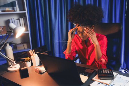 Foto de Mujer africana empresaria o blogger vistiendo camisa rosa con cara seria, mirando y enfocándose en el portátil de pantalla con proyecto de lucha. Concepto de expresión estresante en el trabajo desde casa. Tastemaker. - Imagen libre de derechos