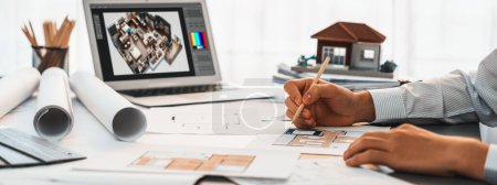 Photo for Interior architect designer at table designing hand drawing house interior blueprint sketch using architecture software, choosing mood board samples for modern precise house renovation design. Insight - Royalty Free Image