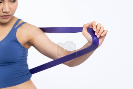 Photo for Vigorous energetic woman in sportswear portrait stretching resistance sport band. Young athletic asian woman strength and endurance training session workout routine concept on isolated background. - Royalty Free Image
