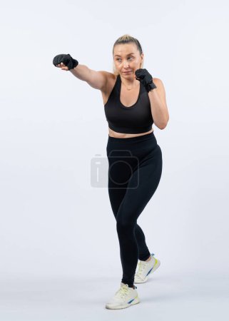 Photo for Full body length shot athletic and sporty senior woman doing boxing and punching fist posture on isolated background. Healthy active physique and body care lifestyle after retirement. Clout - Royalty Free Image