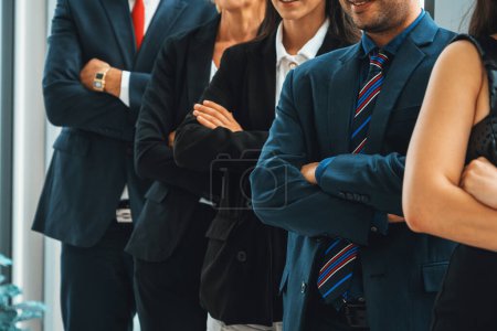Photo for Successful business people standing together showing strong relationship of worker community. A team of businessman and businesswoman expressing a strong group teamwork at the modern office. Jivy - Royalty Free Image