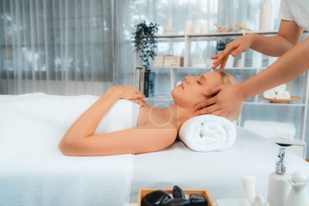 Photo for Caucasian woman enjoying relaxing anti-stress head massage and pampering facial beauty skin recreation leisure in dayspa modern light ambient at luxury resort or hotel spa salon. Quiescent - Royalty Free Image