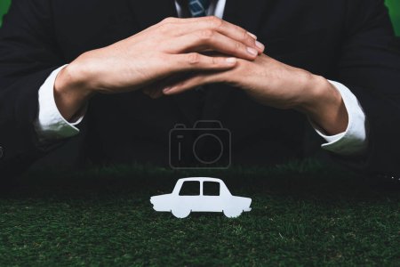 Téléchargez les photos : Un homme d'affaires tenant une icône de voiture électrique symbolise une entreprise respectueuse de l'environnement engagée dans un transport respectueux de l'environnement et zéro émission de CO2. Entreprise responsable et technologie EV. Pneumatique - en image libre de droit