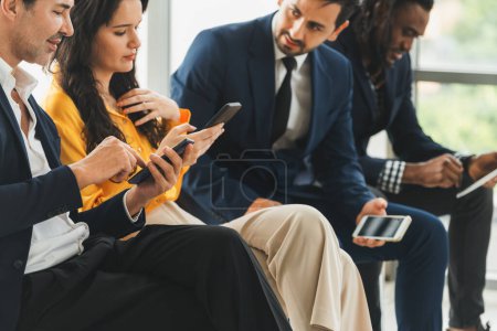 Photo for A group of diversity businessman sitting while sharing their data by using smart phone in side view. Smart businesswoman negotiating about finance information with handsome manager. Intellectual. - Royalty Free Image