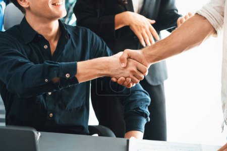 Photo for Diverse group of office employee worker shake hand after making agreement on strategic business marketing meeting. Teamwork and positive attitude create productive and supportive workplace. Prudent - Royalty Free Image