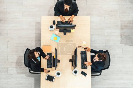 Téléchargez les photos : Les gens d'affaires portant un casque photo de vue de dessus dans le bureau travaillant avec l'ordinateur. Jivy - en image libre de droit