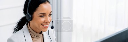 Foto de Mujer de negocios afroamericana con auriculares que trabajan en la oficina para apoyar a un cliente o colega crucial remoto. Centro de llamadas, telemarketing, agente de atención al cliente proporcionar servicio en videollamada. - Imagen libre de derechos