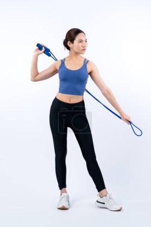 Photo for Young energetic asian woman in sportswear with jumping or skipping robe posing portrait in studio shot on isolated background. Cardio exercise tool and healthy body care lifestyle. Vigorous - Royalty Free Image