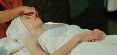 Photo for A beautiful young caucasian woman having facial massage while lies on spa bed surrounded by electrical beauty equipment. Beauty facial mask. Surrounded by medical equipment at spa salon. Tranquility. - Royalty Free Image