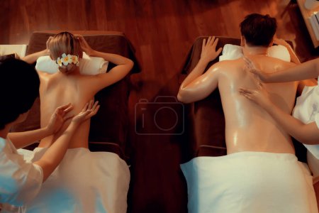 Téléchargez les photos : Vue de dessus couple client appréciant relaxant massage spa anti-stress et dorloter avec beauté loisirs de la peau dans la bougie chaude éclairage spa salon d'ambiance au complexe de luxe ou à l'hôtel. Tranquillité - en image libre de droit
